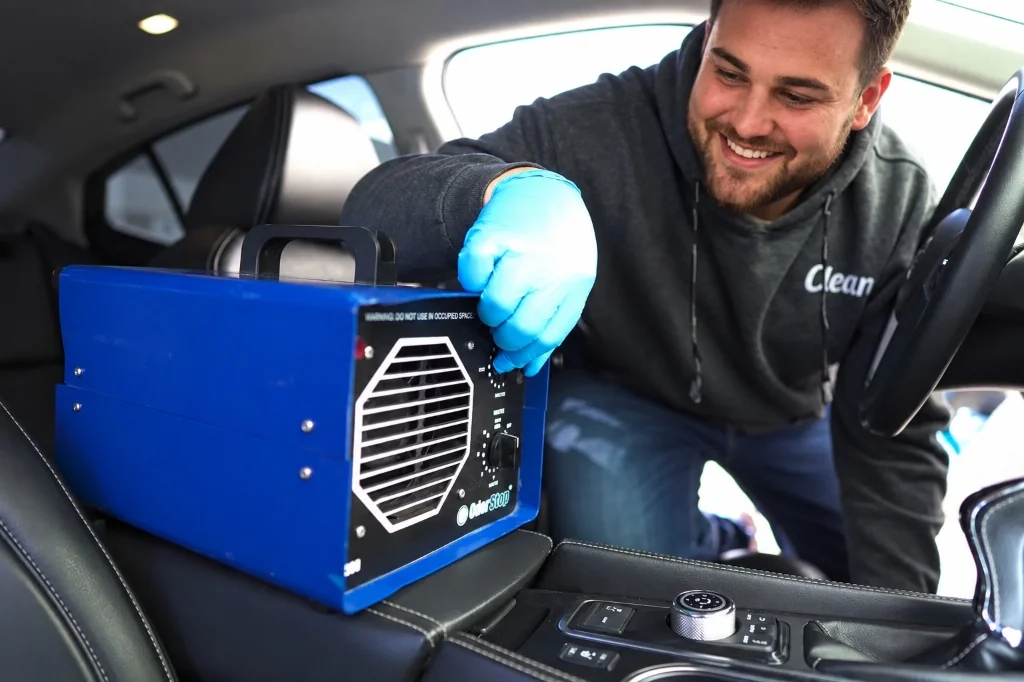 CleanWorx auto detailer operating an OdorStop ozone generator inside a vehicle interior for odor removal in Basking Ridge, NJ