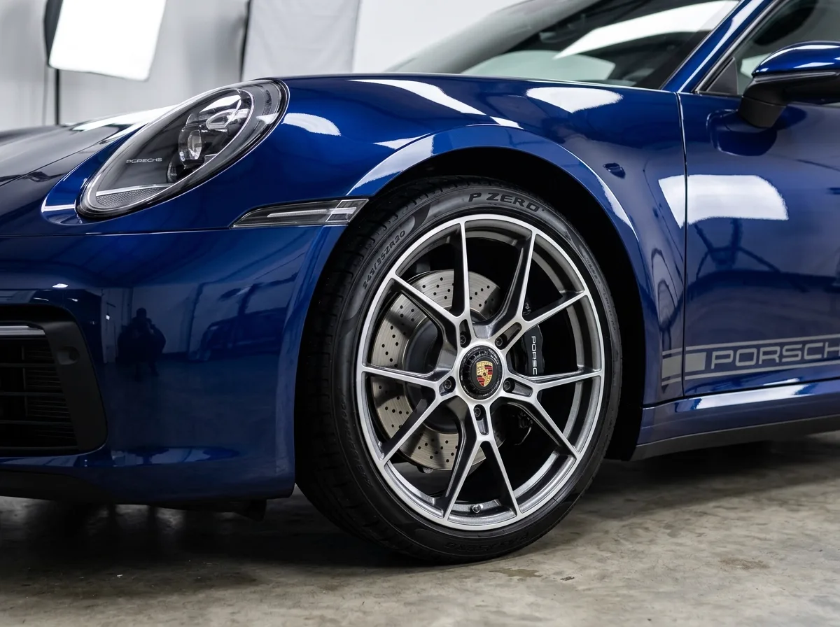 Vehicle wheel, dressed tire, and glossy paint finish after CleanWorx complete exterior hand wash and decontamination detail